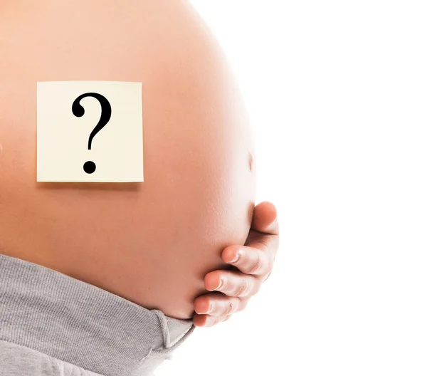 Belly of a young pregnant woman with a white sticker — Stock Photo, Image