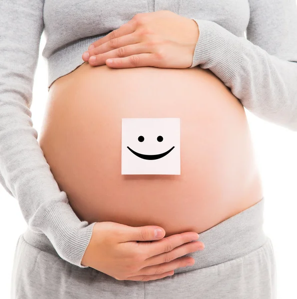 Belly of a young pregnant woman with a white sticker — Stock Photo, Image