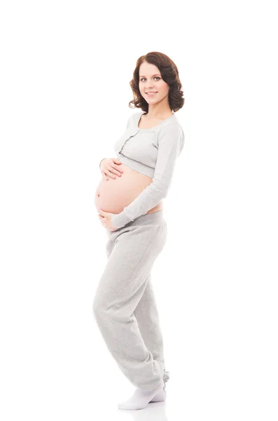 Una joven morena embarazada aislada sobre un fondo blanco Imágenes de stock libres de derechos