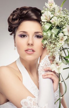 çiçek demeti ile duran genç ve güzel gelini