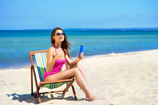 Una joven en traje de baño relajándose en la playa — Foto de Stock
