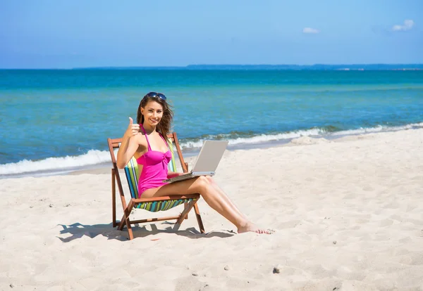 Una giovane donna in costume da bagno si rilassa sulla spiaggia — Foto Stock