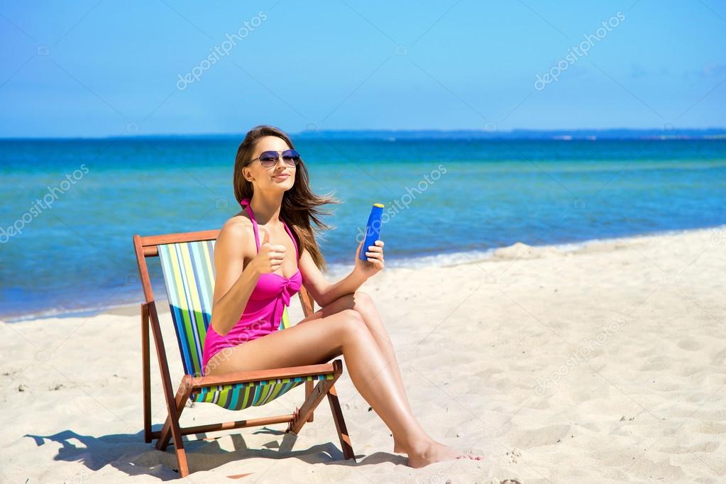 A young woman in a swimsuit relaxing on the beach