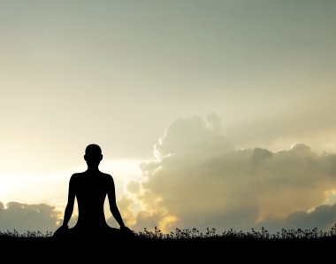 Yoga yapan bir kadının silüeti.
