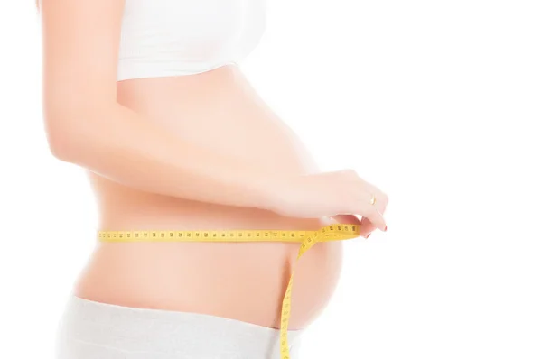 Una giovane donna bionda incinta con un metro — Foto Stock