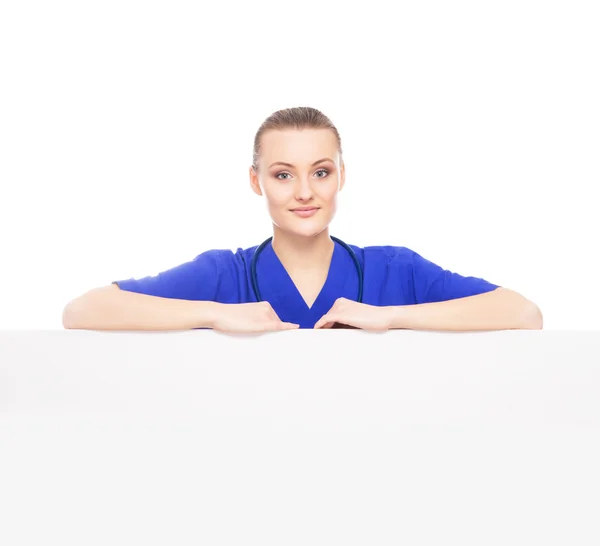 Female doctor standing over big blank billboard — Stock Photo, Image