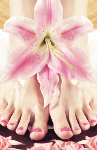 Female legs with a lily flower — Stock Photo, Image