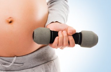 Pregnant woman working out with dumbbells clipart