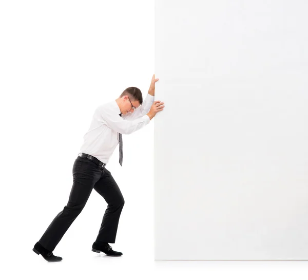 Homem de negócios empurrando um grande banner em branco — Fotografia de Stock