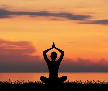 günbatımı üzerinde meditasyon bir genç kadın silüeti