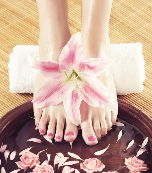 Spa background with a beautiful legs, flowers, petals — Stock Photo, Image