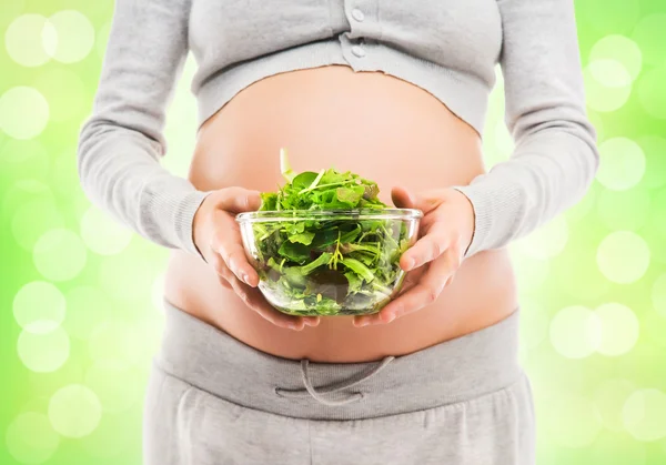 A pregnant woman holding a fresh green salad — Stock Photo, Image