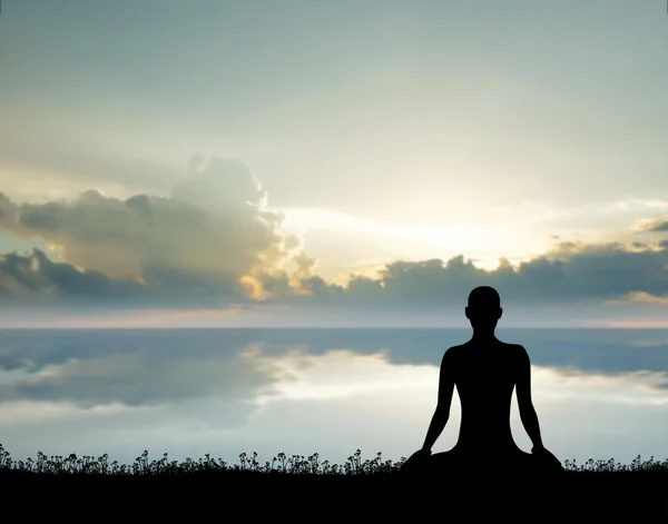 Silhouette of a young woman meditating on a sunset — Stock Photo, Image