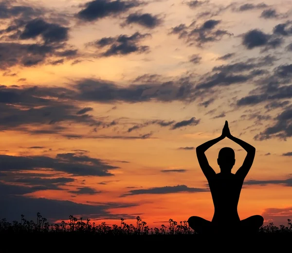 Silueta mladé ženy meditaci na západ slunce Stock Obrázky