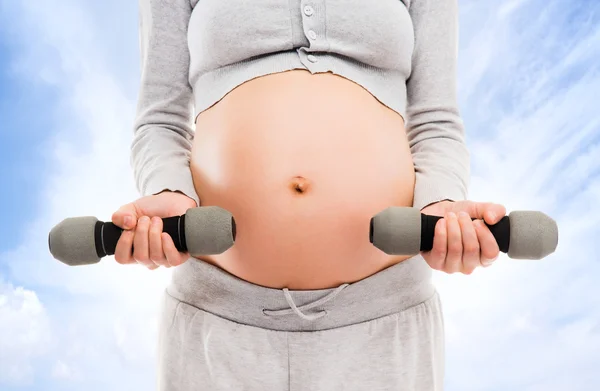 Pregnant woman with dumbbells — Stock Photo, Image