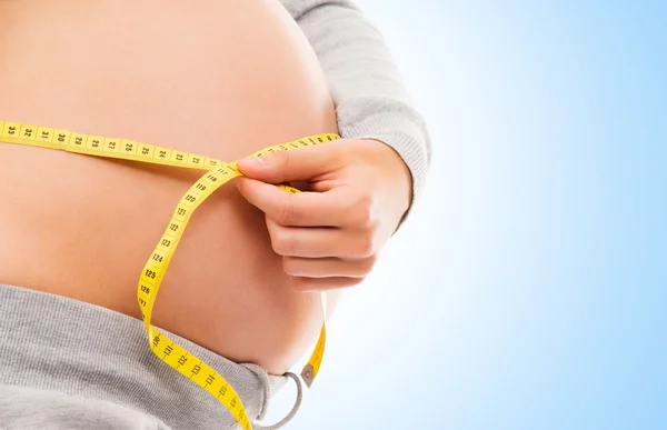 Pregnant woman measuring her belly — Stock Photo, Image