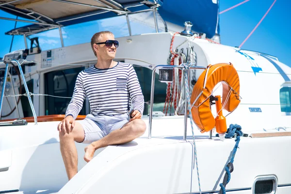 Knappe man op zeilboot — Stockfoto