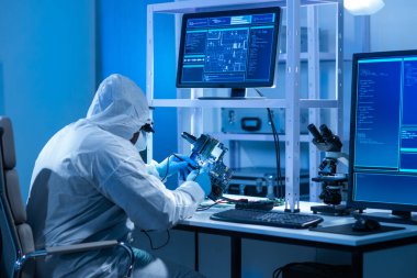 Afrikalı-Amerikalı bilim adamı, mikro elektronik ve işlemcilerin araştırılması ve geliştirilmesi için modern bir bilim laboratuvarında çalışıyor. Üretim işçisi bilgisayar teknolojisi ve ekipmanı kullanıyor.