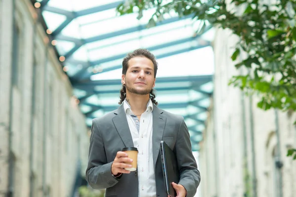 Um jovem empresário de sucesso está andando pela rua. Um homem de fato casual. Trabalho de negócios, freelance e remoto. — Fotografia de Stock