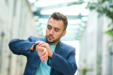 Genç ve başarılı bir iş adamı dışarıda çalışıyor. Sıradan giysili bir adam. İş, serbest meslek ve uzak çalışma.