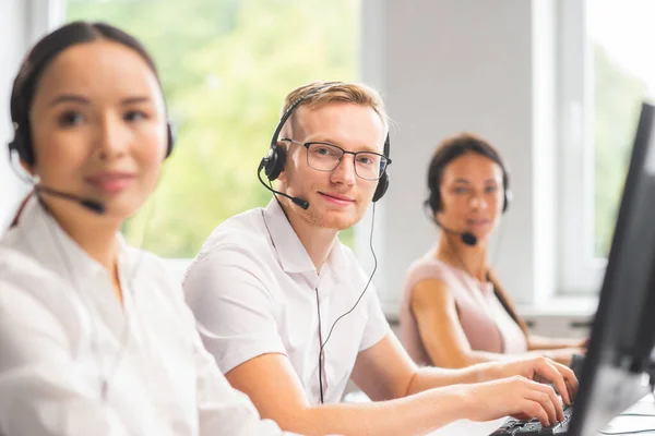 Equipe diversa de jovens profissionais está trabalhando no escritório de suporte telefônico. Dia de trabalho de gerentes de vendas no call center. Negócios, consultoria telefônica e resolução de problemas. — Fotografia de Stock