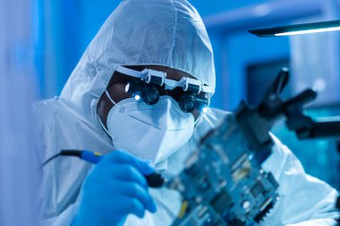 Afrikalı-Amerikalı bilim adamı, mikro elektronik ve işlemcilerin araştırılması ve geliştirilmesi için modern bir bilim laboratuvarında çalışıyor. Üretim işçisi bilgisayar teknolojisi ve ekipmanı kullanıyor.