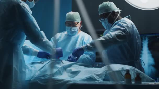 Multiracial team av professionella medicinska kirurger utför den kirurgiska operationen på ett modernt sjukhus. Läkarna arbetar för att rädda patienten. Medicin, hälsa, kardiologi och transplantation. — Stockvideo