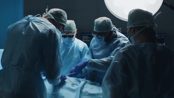 Profesyonel tıp cerrahlarından oluşan çok ırklı bir ekip modern bir hastanede cerrahi operasyon gerçekleştiriyor. Doktorlar hastayı kurtarmaya çalışıyor. İlaç, sağlık, kardiyoloji ve organ nakli. — Stok video