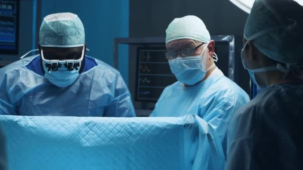 Многорасовая команда профессиональных медицинских хирургов проводит хирургическую операцию в современной больнице. Врачи работают, чтобы спасти пациента. Медицина, здоровье и нейрохирургия. — стоковое видео