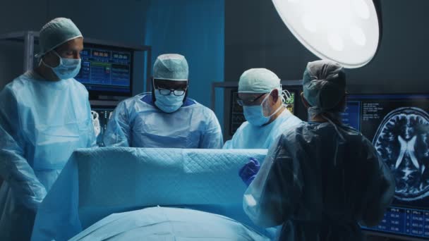 Multiracial team av professionella medicinska kirurger utför den kirurgiska operationen på ett modernt sjukhus. Läkarna arbetar för att rädda patienten. Medicin, hälsa och neurokirurgi. — Stockvideo