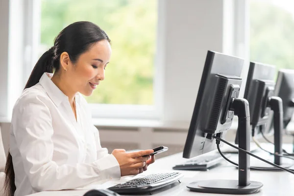 Aziatische zakenvrouw werkt aan haar tafel in een modern kantoor. De werkplek van een succesvolle specialist. Bedrijven, vertrouwen en financiën. — Stockfoto