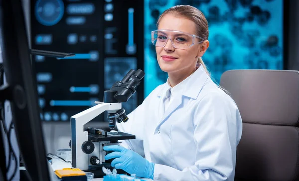 Kadın doktor, bilgisayar teknolojileri ve ekipman kullanarak modern bir bilim laboratuarında çalışıyor. Bilim adamı araştırma yapar ve yeni aşılar geliştirir. Bilim ve sağlık konsepti. — Stok fotoğraf