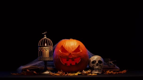 Calabaza riéndose de miedo y un viejo cráneo sobre un fondo oscuro. Halloween, brujería y magia. — Vídeo de stock