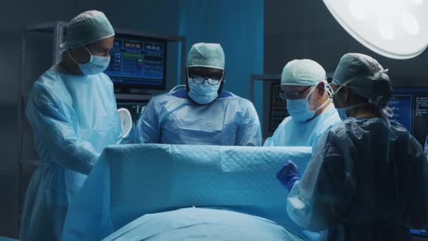 Wielorasowy zespół profesjonalnych lekarzy wykonuje operację chirurgiczną w nowoczesnym szpitalu. Lekarze pracują nad ratowaniem pacjenta. Medycyna, zdrowie i neurochirurgia. — Wideo stockowe
