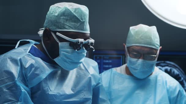 El equipo multirracial de cirujanos médicos profesionales realiza la operación quirúrgica en un hospital moderno. Los médicos están trabajando para salvar al paciente. Medicina, salud y neurocirugía. — Vídeo de stock