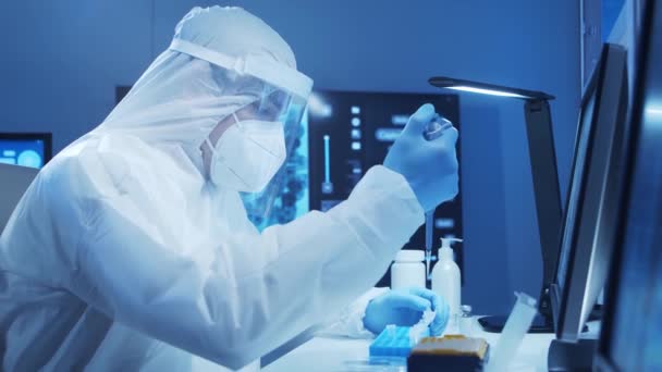 보호 복을 입은 의사는 현대 실험실에서 과학 실험을 하고 백신을 개발하고 있습니다. 연구소 보조 업무. 과학 과 의학이라는 개념 은. — 비디오