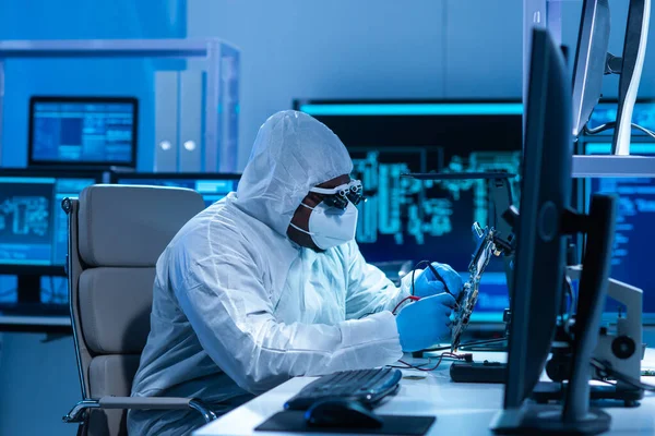 African-American scientist works in a modern scientific laboratory for the research and development of microelectronics and processors. Manufacturing worker uses computer technology and equipment.