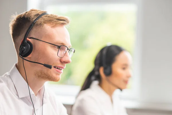 Equipe diversa de jovens profissionais está trabalhando no escritório de suporte telefônico. Dia de trabalho de gerentes de vendas no call center. Negócios, consultoria telefônica e resolução de problemas. — Fotografia de Stock