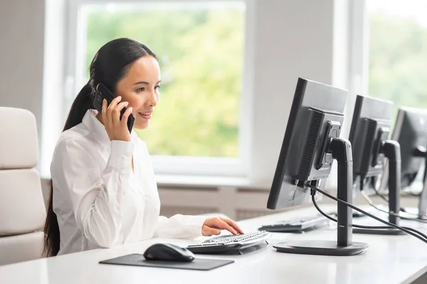 Mujer de negocios asiática está trabajando en su mesa en una oficina moderna. El lugar de trabajo de un especialista exitoso. Negocios, confianza y finanzas. — Foto de Stock