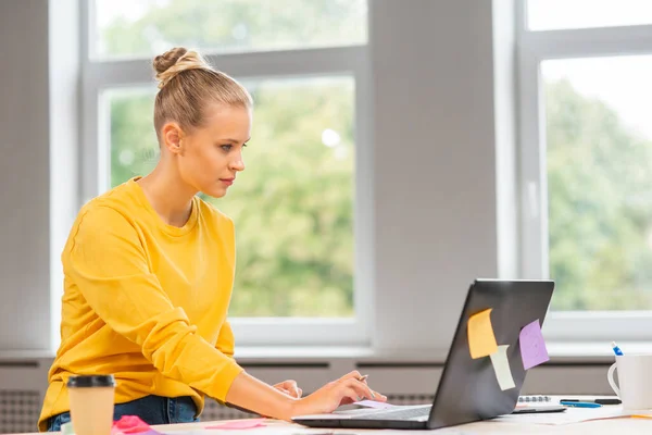 프리랜서 직원의 직장 또는 가정 사무실의 여학생. 젊은 여자는 컴퓨터와 그 밖의 장치를 사용하여 일합니다. 원격 직업 개념. — 스톡 사진