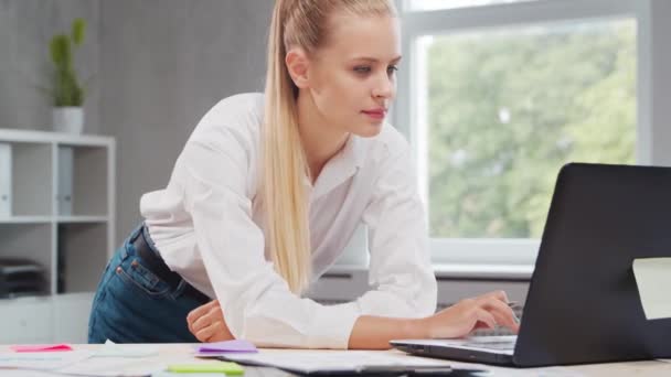 Werkplaats van een freelancer of een studente op kantoor. Jonge vrouw werkt met behulp van computer en andere apparaten. Afstandswerkconcept. — Stockvideo