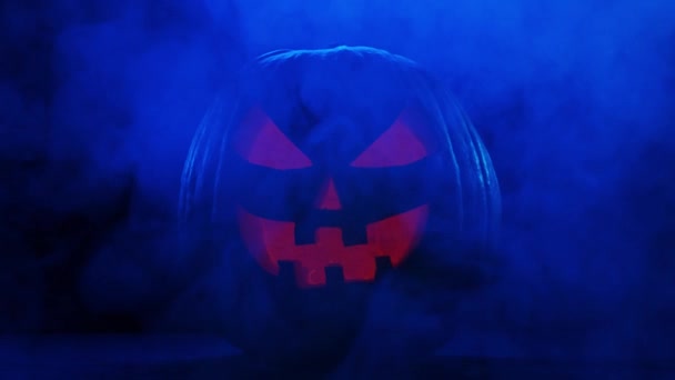 Gruselig lachender Kürbis auf dunklem Hintergrund. Halloween, Hexerei und Magie. — Stockvideo