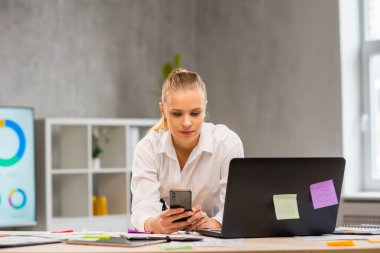 Serbest çalışan bir işçinin ya da öğrenci bir kızın çalıştığı yer. Genç kadın bilgisayar ve diğer cihazları kullanarak çalışıyor. Uzak görev konsepti.