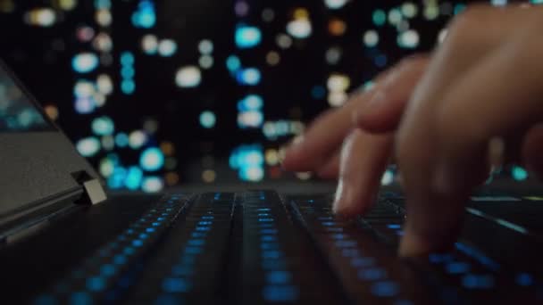 Bilgisayarda çalışan genç bir adamın elleri. Programcı bir oyun dizüstü bilgisayarında yazıyor. Arka planda Gece Şehri. İş, kodlama ve takas kavramı. — Stok video