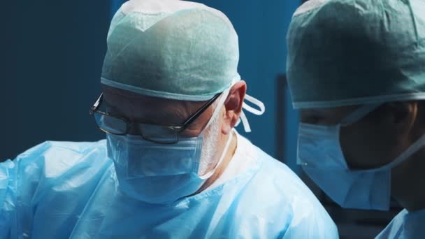 Multiracial team av professionella medicinska kirurger utför den kirurgiska operationen på ett modernt sjukhus. Läkarna arbetar för att rädda patienten. Medicin, hälsa, kardiologi och transplantation. — Stockvideo