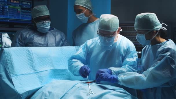 Многорасовая команда профессиональных медицинских хирургов проводит хирургическую операцию в современной больнице. Врачи работают, чтобы спасти пациента. Медицина, здоровье, кардиология и трансплантация. — стоковое видео