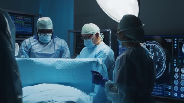 Professzionális orvosi sebészek multiracionális csapata végzi a műtétet egy modern kórházban. Az orvosok azon dolgoznak, hogy megmentsék a beteget. Gyógyászat, egészségügy és idegsebészet. — Stock videók