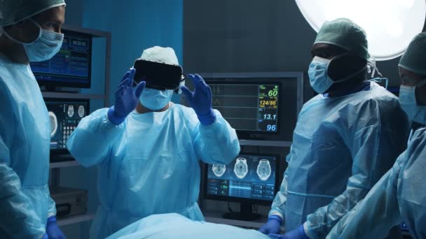 El equipo multirracial de cirujanos médicos profesionales realiza la operación quirúrgica en un hospital moderno utilizando la tecnología de realidad virtual. Concepto de medicina, salud y neurocirugía. — Vídeos de Stock