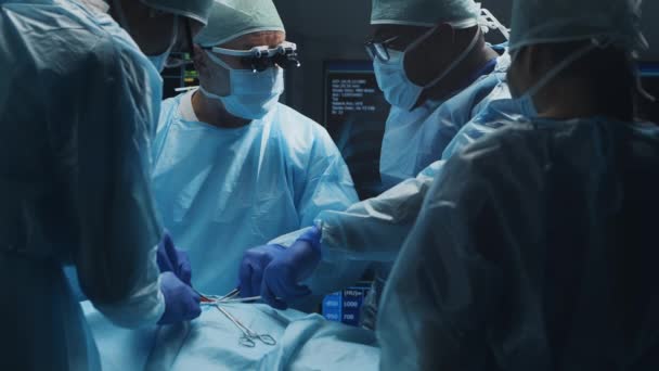 El equipo multirracial de cirujanos médicos profesionales realiza la operación quirúrgica en un hospital moderno. Los médicos están trabajando para salvar al paciente. Medicina, salud, cardiología y trasplante. — Vídeo de stock