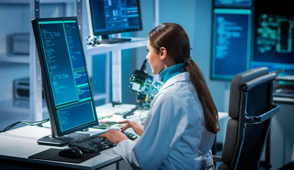 Lugar de trabajo de la mujer joven en el laboratorio de fabricación de microelectrónica moderna. Ingeniero trabaja en un moderno laboratorio científico sobre sistemas informáticos y microprocesadores. —  Fotos de Stock